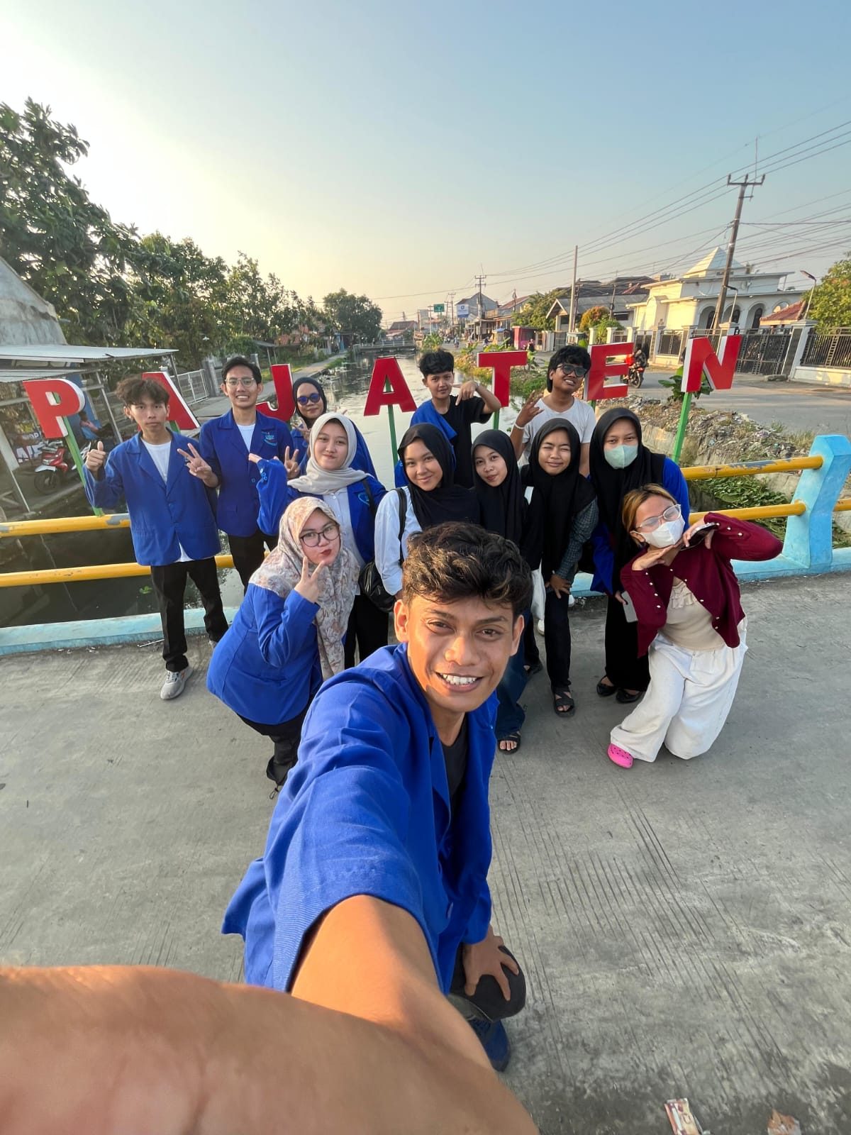 Anggota KKN berfoto di depan tulisan Pajaten